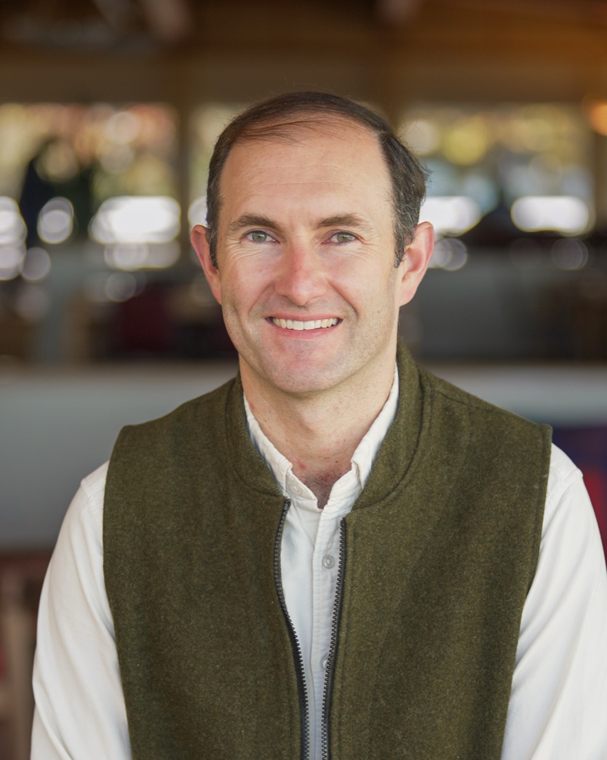 Andrew Keaveney smiling, wearing an olive vest